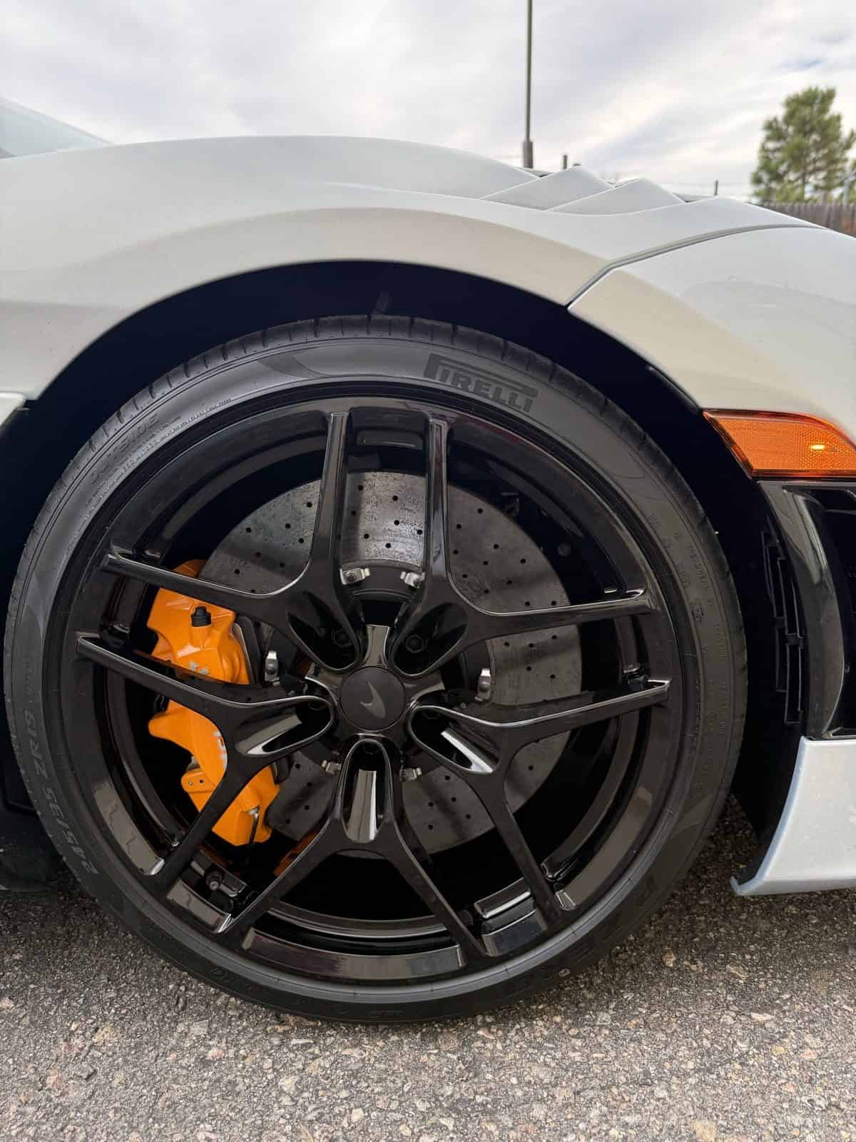 McLaren 720S orange caliper behind black wheel Denver