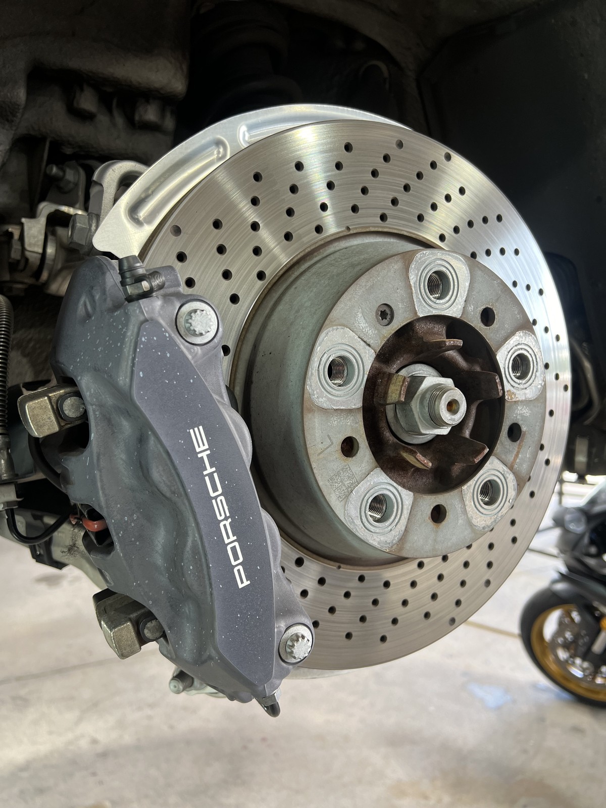 Porsche caliper before grey stock drilled rotor